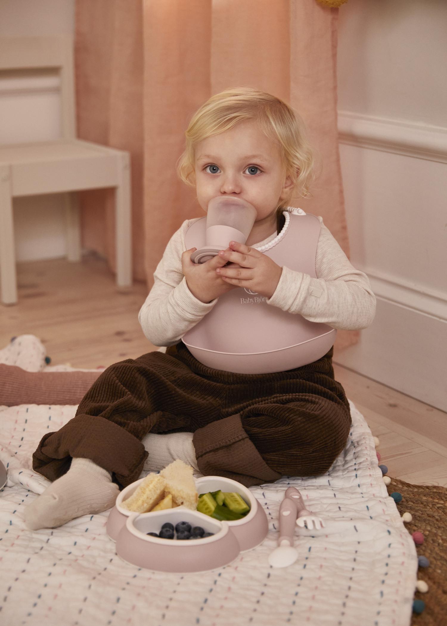 Baby Bib in powder green with a big spill pocket - BabyBjörn