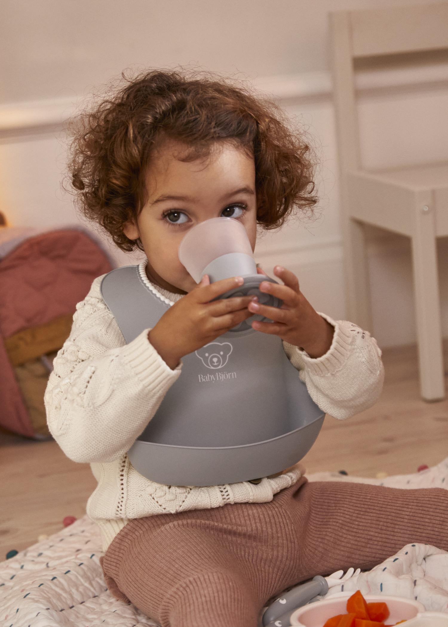 Baby Bib in gray with a big spill pocket - BabyBjörn